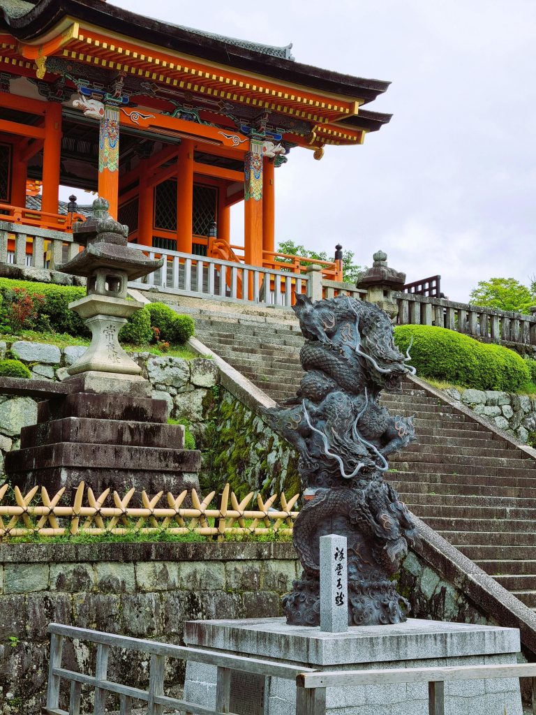 Majestic view of a Japanese temple entrance with intricate dragon statue and vibrant architecture.
